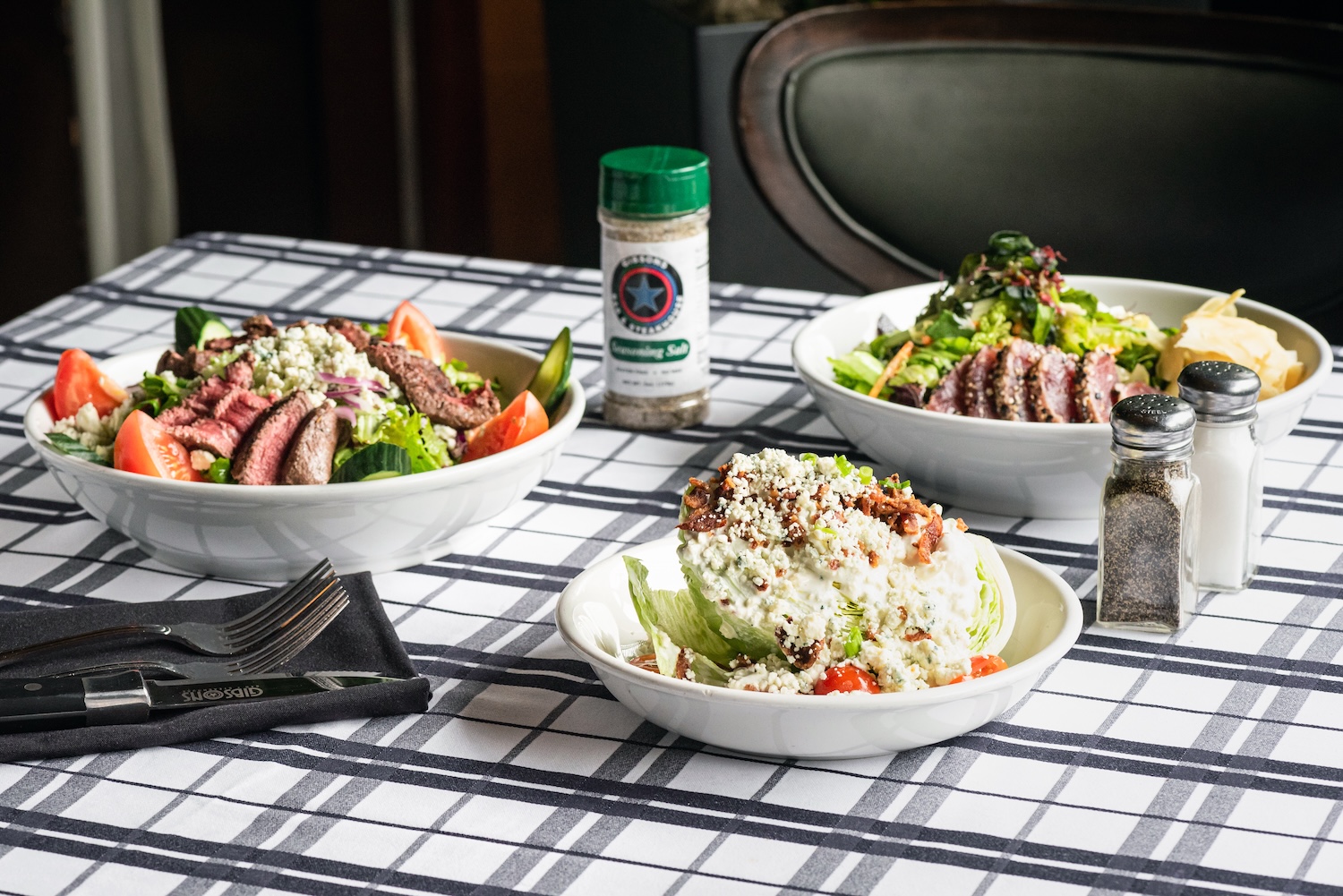 A crisp, artfully arranged trio of salads served at Gibsons Bar & Steakhouse in Chicago, showcasing  