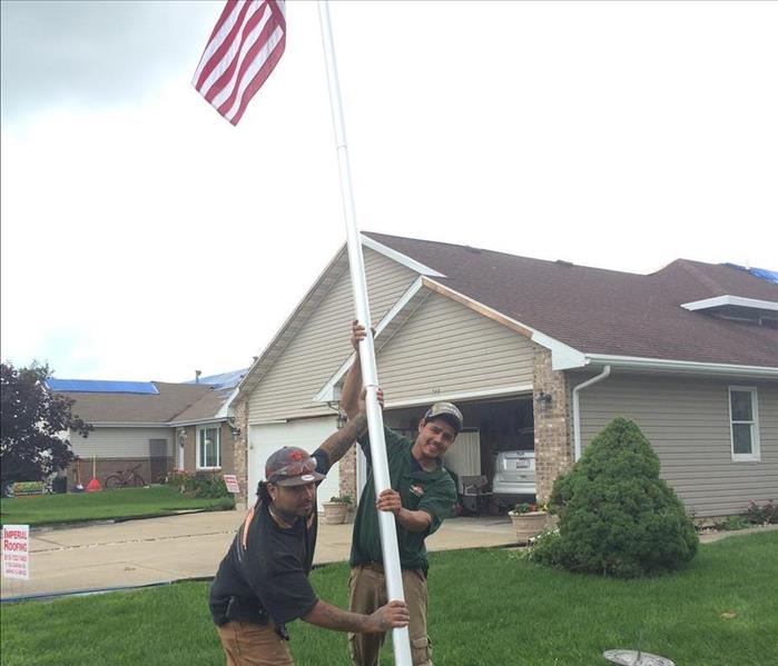 Pictured here are several members our SERVPRO of Buffalo Grove / Lake Zurich team raising the American flag at a customer's home to restore hope to a severely damaged area of Coal City, IL With pride, we help our friends and neighbors.