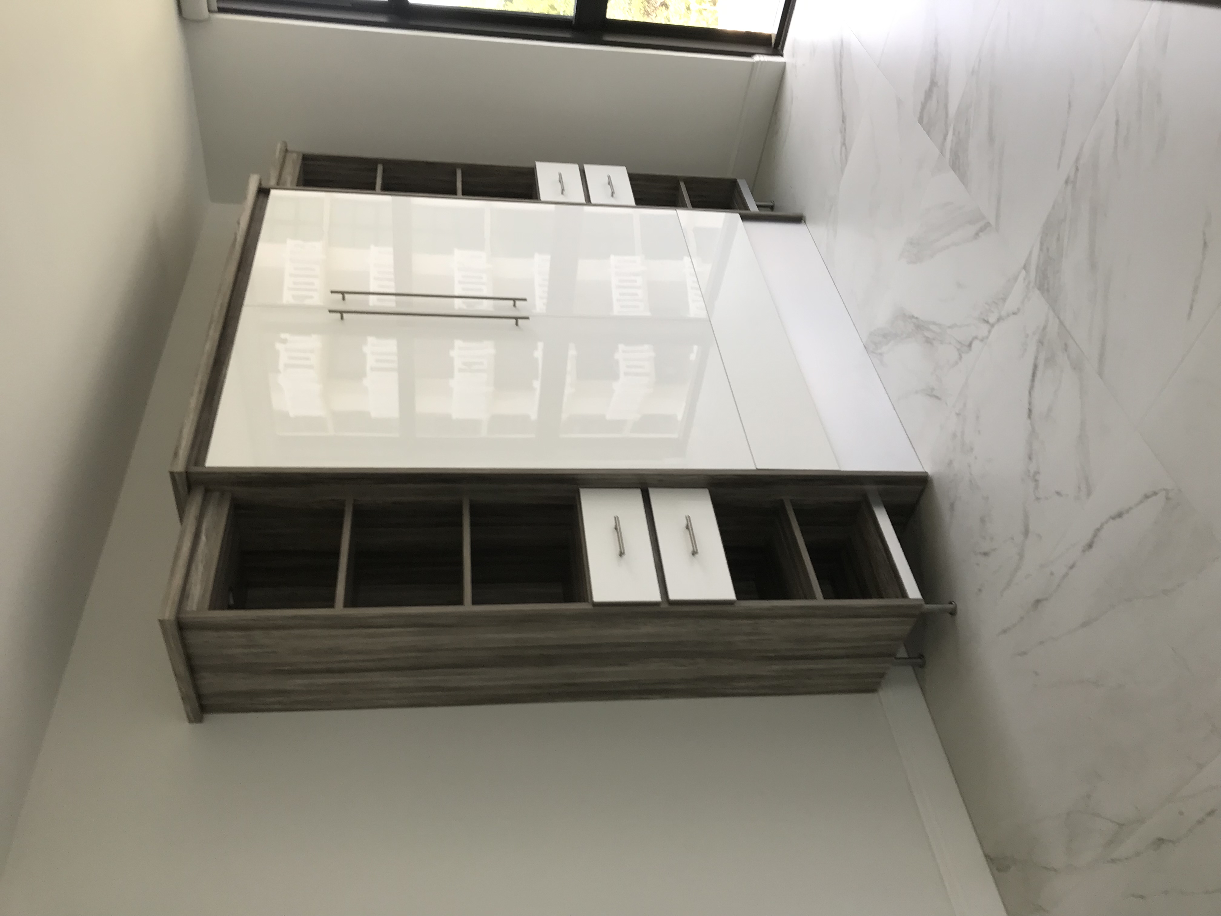 Modern Murphy bed cabinet closed with white high gloss panels and side shelving