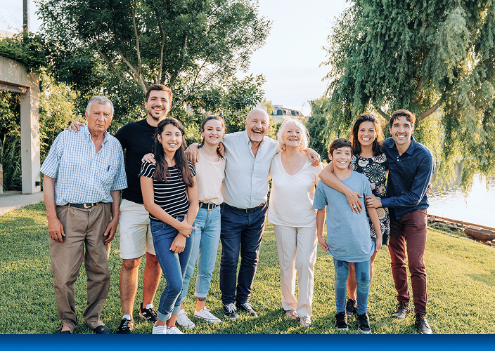 A multigenerational family posing for a photo in their backyard.
