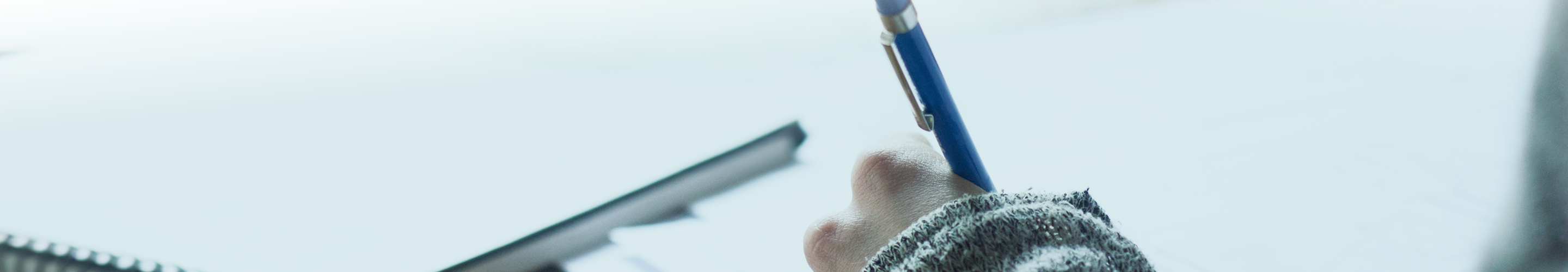A close-up shot of an individual writing in a journal.