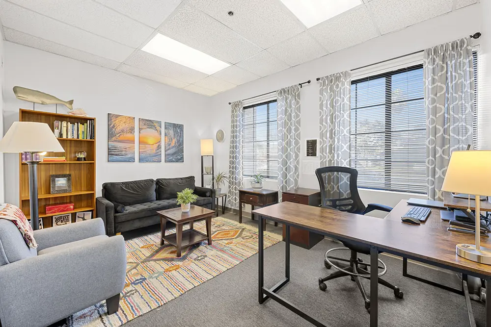 Well-lit rooms furnished with sofas and tables to provide a comfortable and peaceful environment for therapy, reflection, and recovery support.