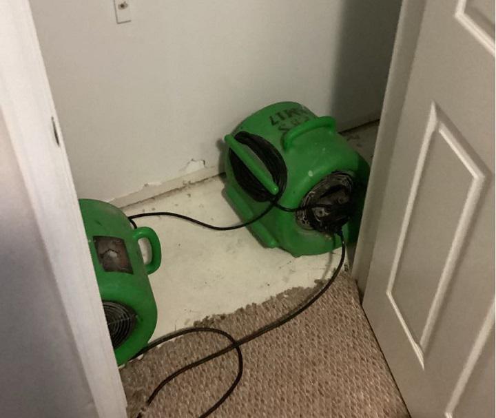 Water damaged closet; carpet remove. SERVPRO restoration equipment being used