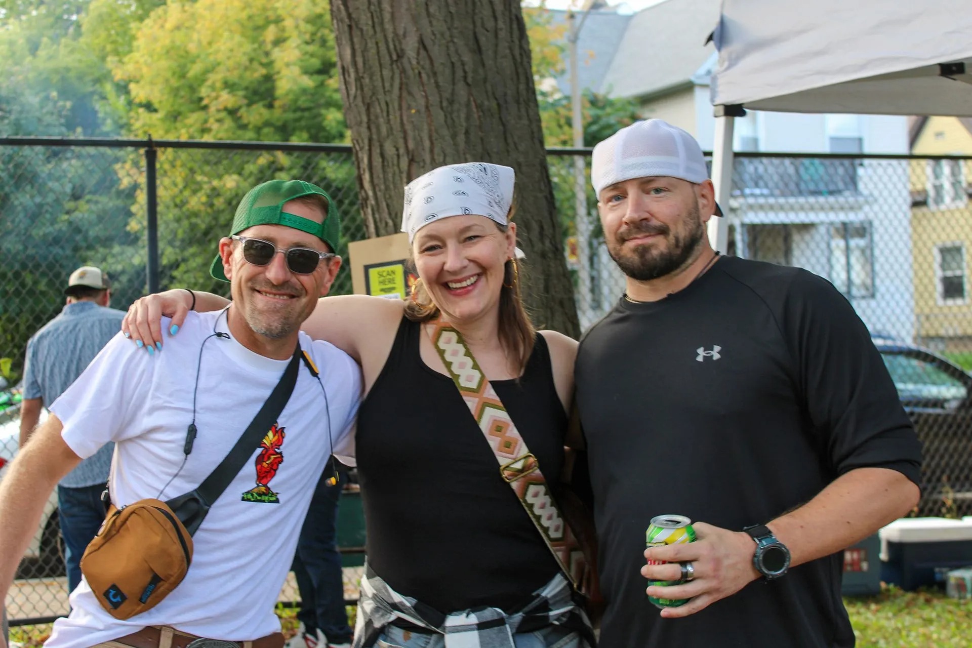 Three smiling attendees pose together during an outdoor community event, celebrating friendship, connection, and recovery while enjoying a welcoming atmosphere that encourages meaningful relationships and positive sober living experiences together.