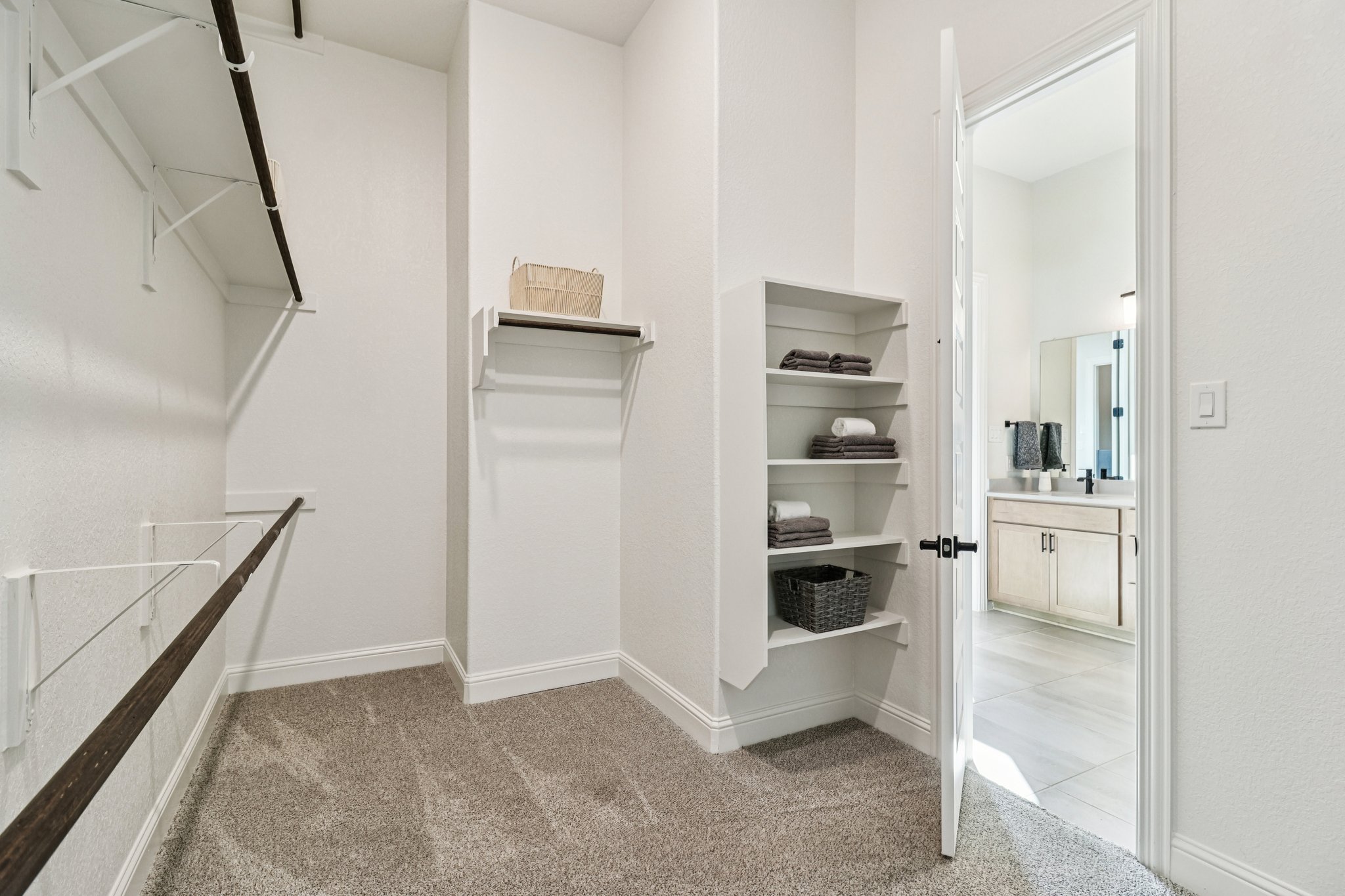 Owner's Closet features Three Rows of Clothing Rods for Ample Storage as well as Built-in Shelving 
