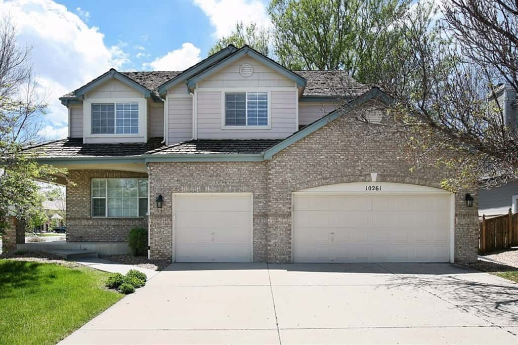 Front of home with a three car garage at Invitation Homes Denver.