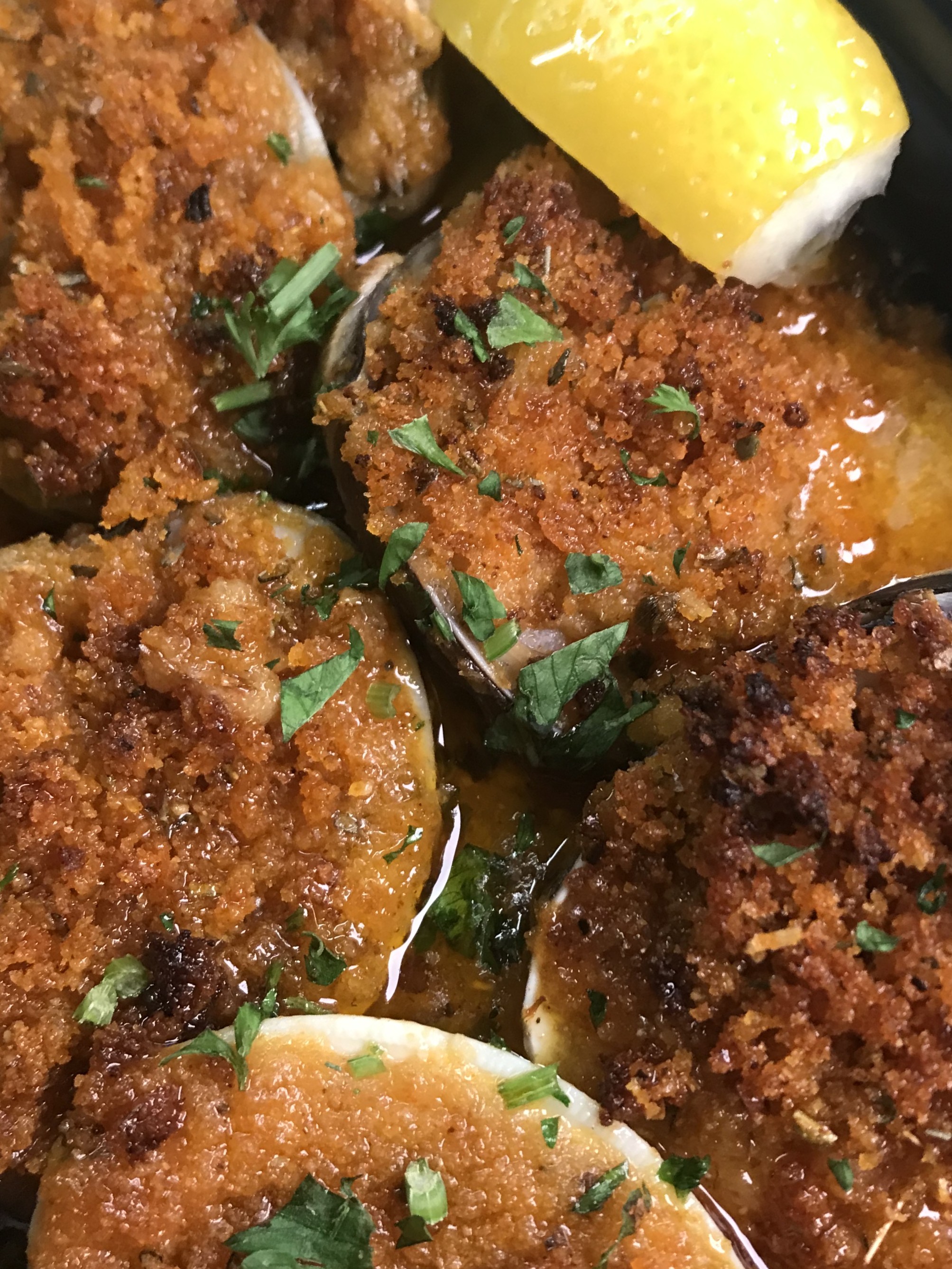 Little Neck  Clams topped with seasoned bread crumbs in a garlic sauce
