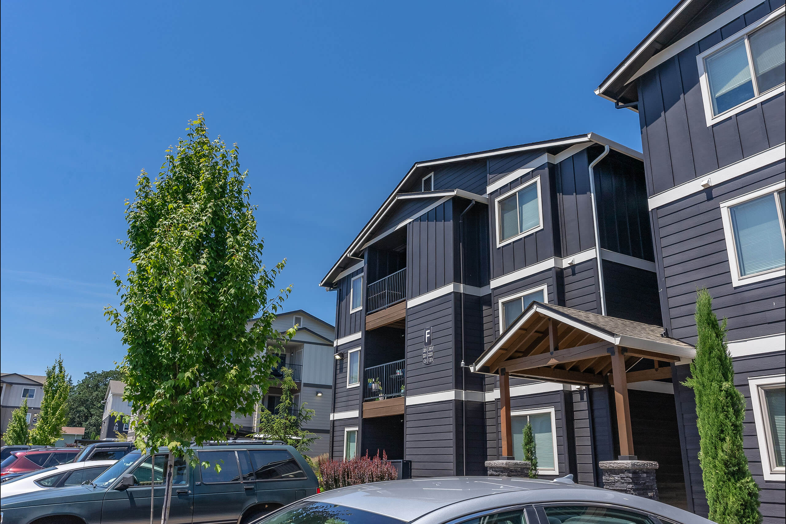 A grey building with a tree in front of it.