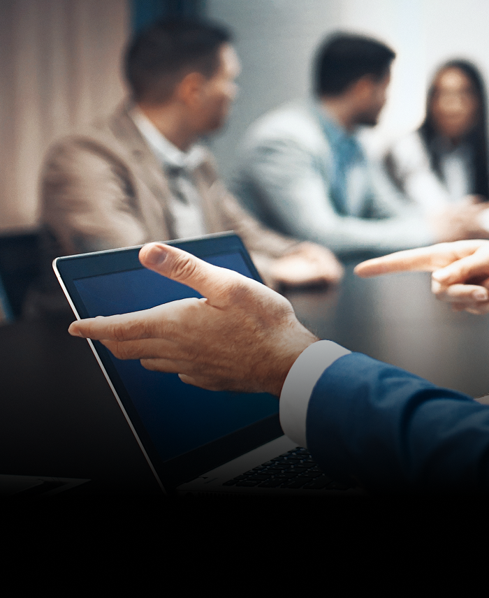 Close-up of a professional working on their laptop during a meeting.