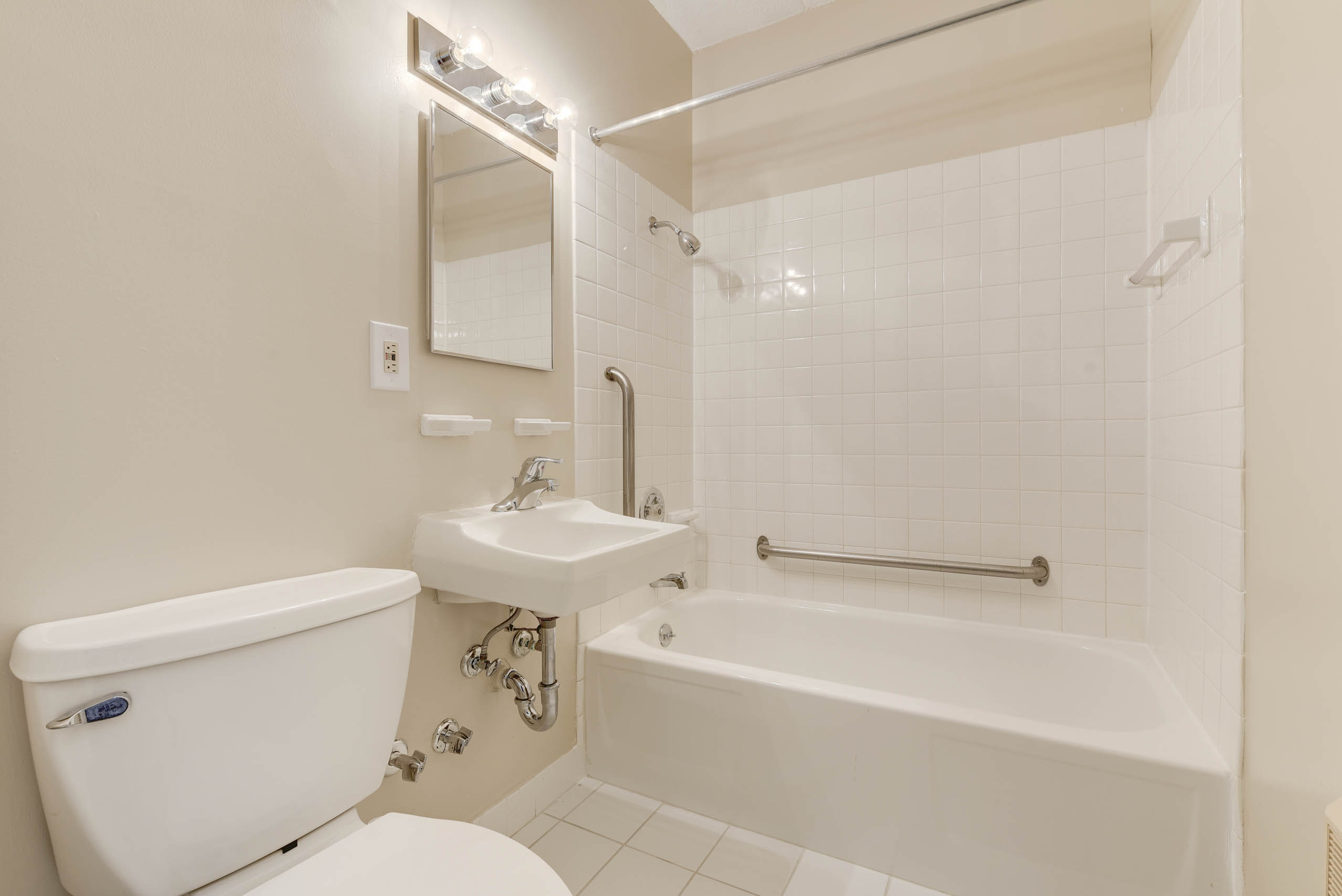 A white bathroom with a tub, sink, and toilet.