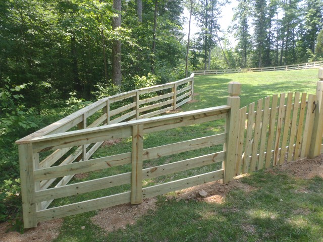 Four board fence with cap board and picket style gate with a round top. All pressure treated pine material.