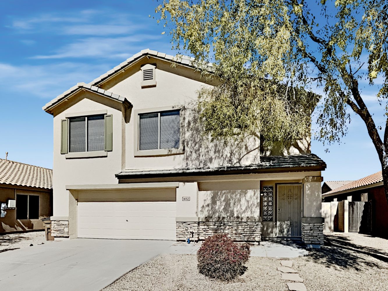 Front of home with two-car garage and covered porch at Invitation Homes Phoenix.