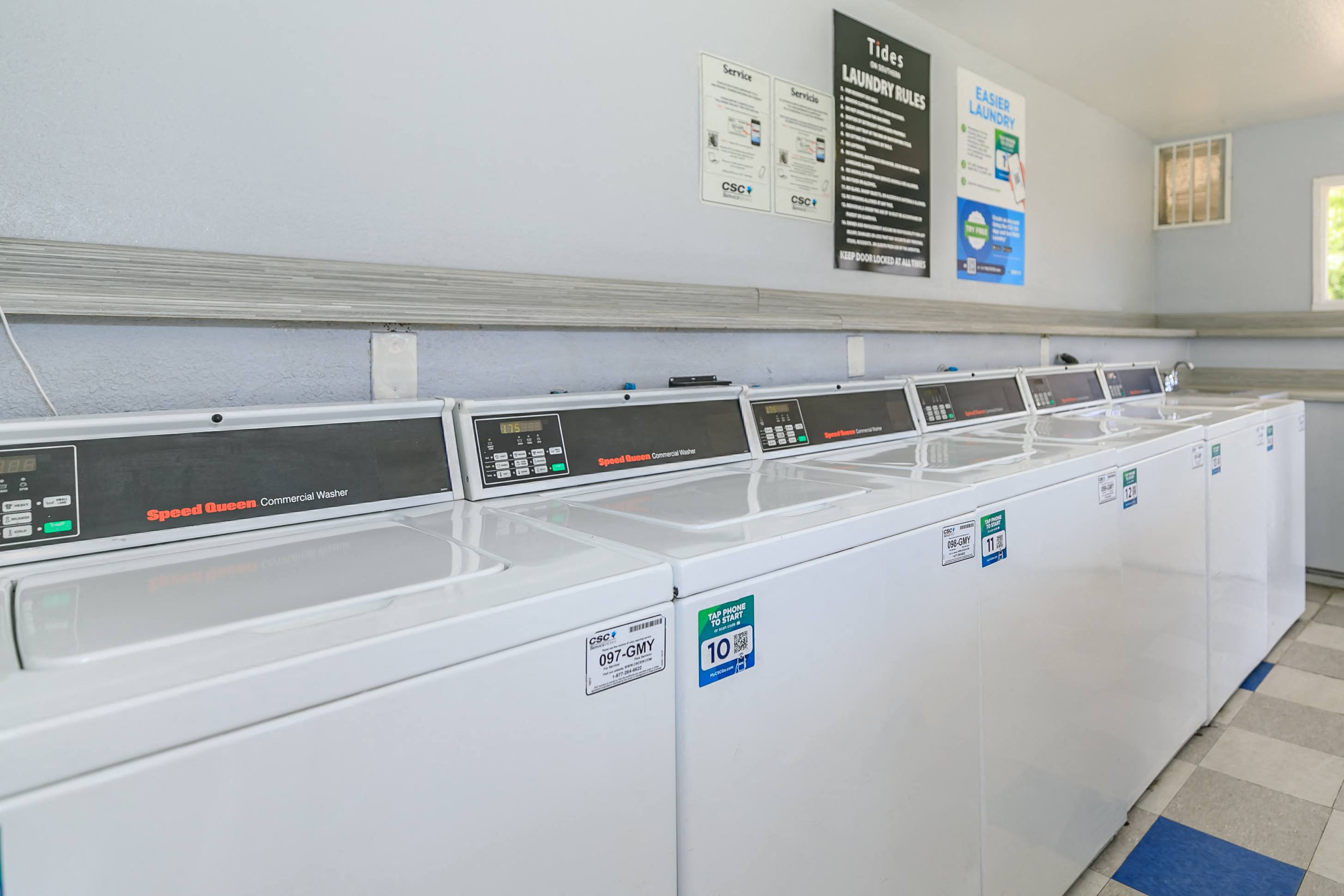 a row of washers and dryers in a laundry room