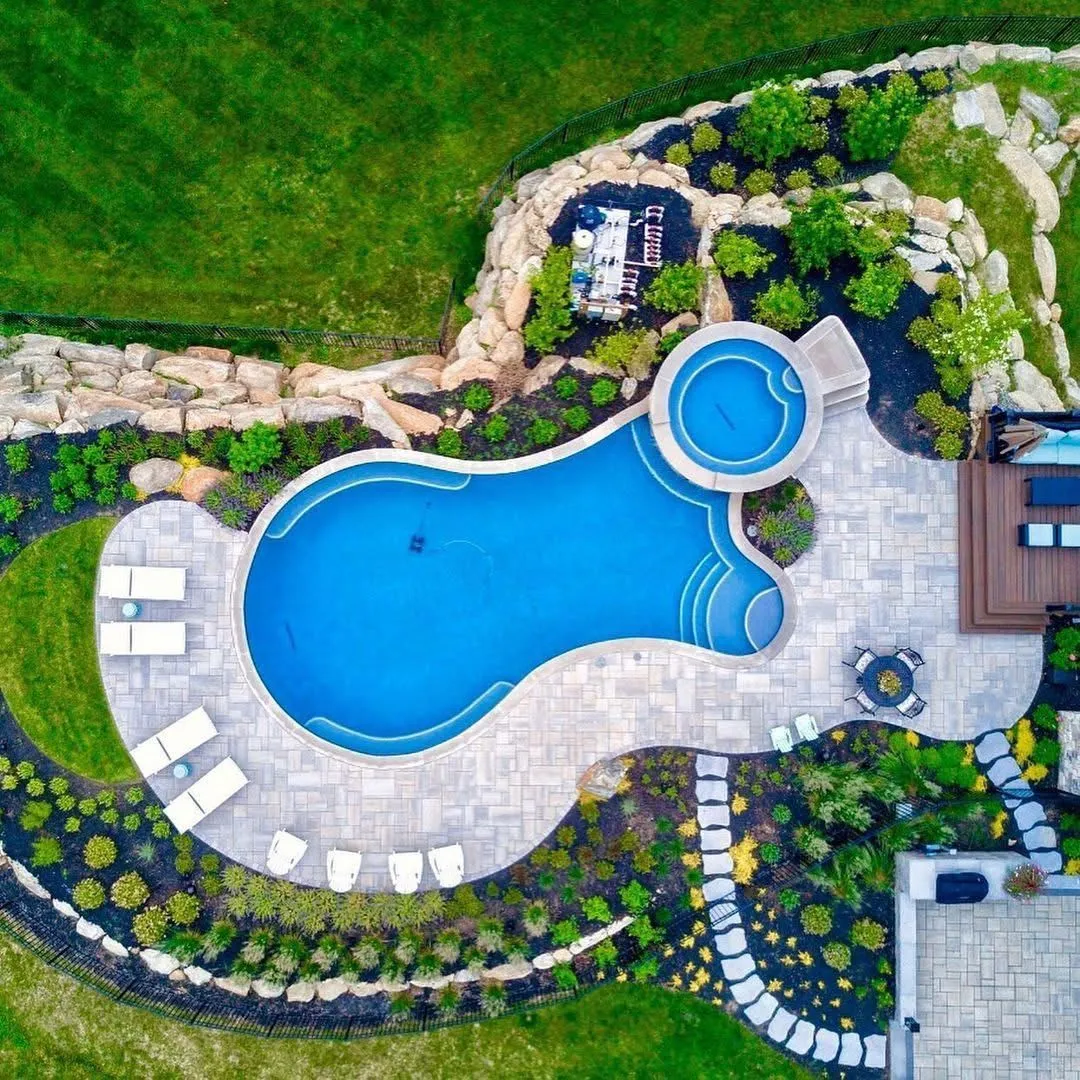 This drone shot showcases Zamora Design and Build's mastery in creating high-end outdoor living spaces, complete with a stunning pool, spa, ample lounging areas, and meticulously designed greenery.