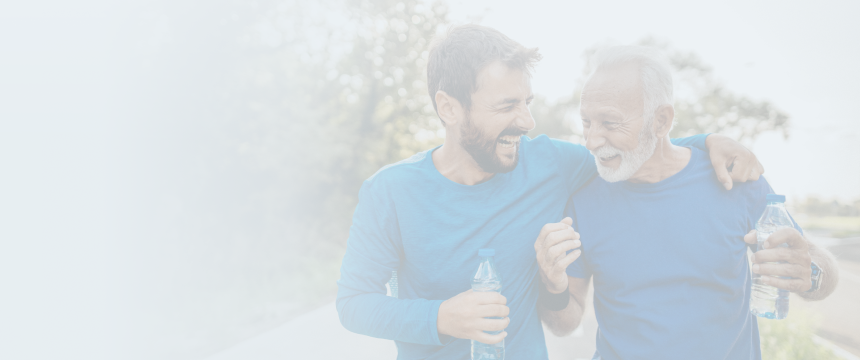 A son laughing alongside his elderly father while they exercise together.
