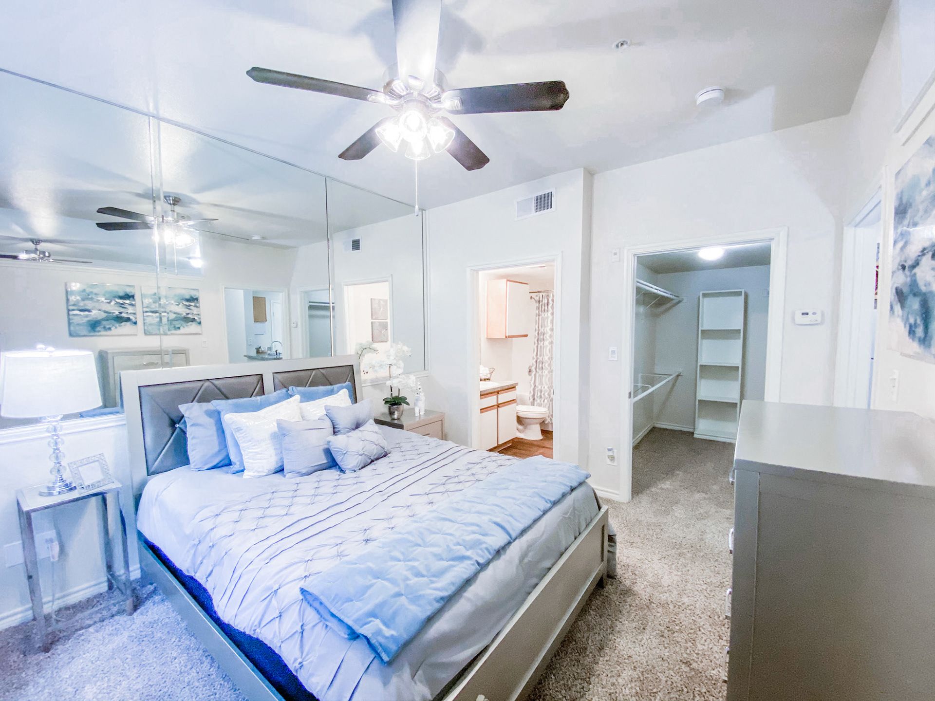 Bedroom with large mirrors and ceiling fan
