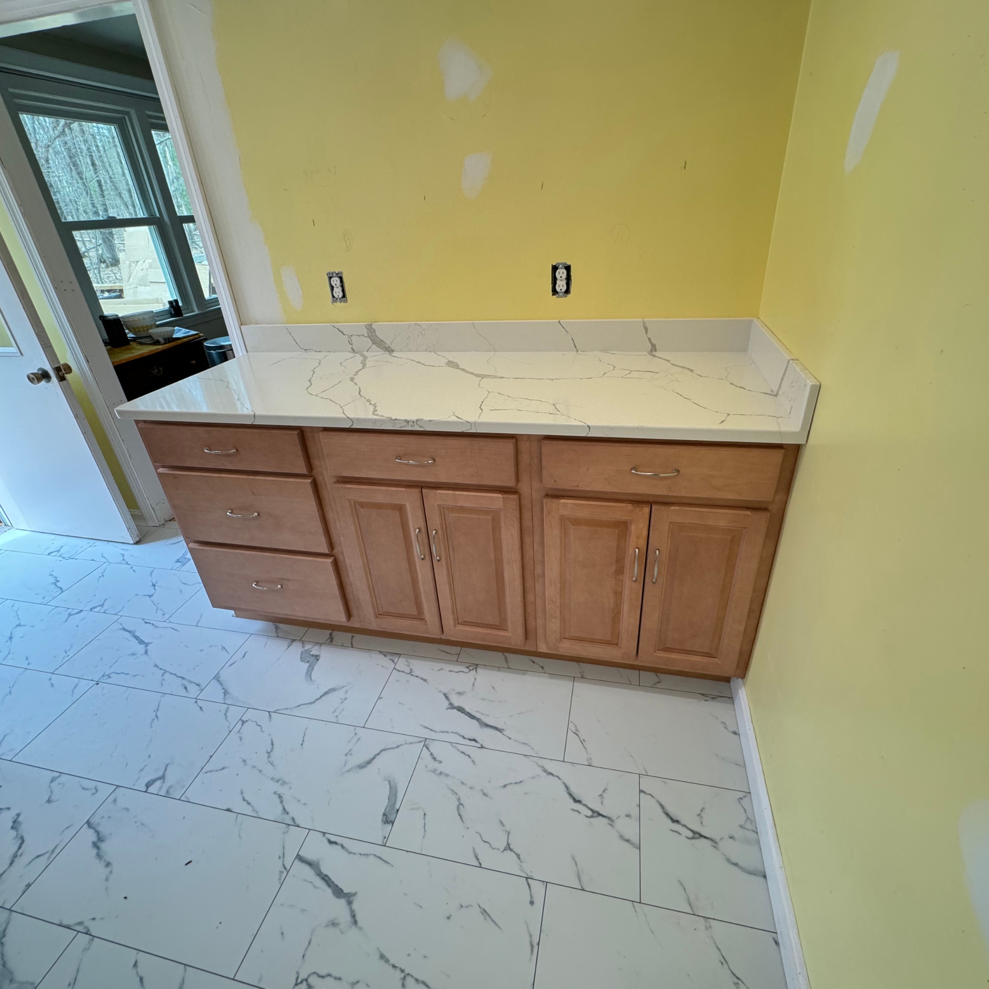 Custom bathroom vanity with a marble countertop and wooden cabinets. Freshly installed in a modern home renovation project. Ideal for enhancing bathroom aesthetics and functionality.