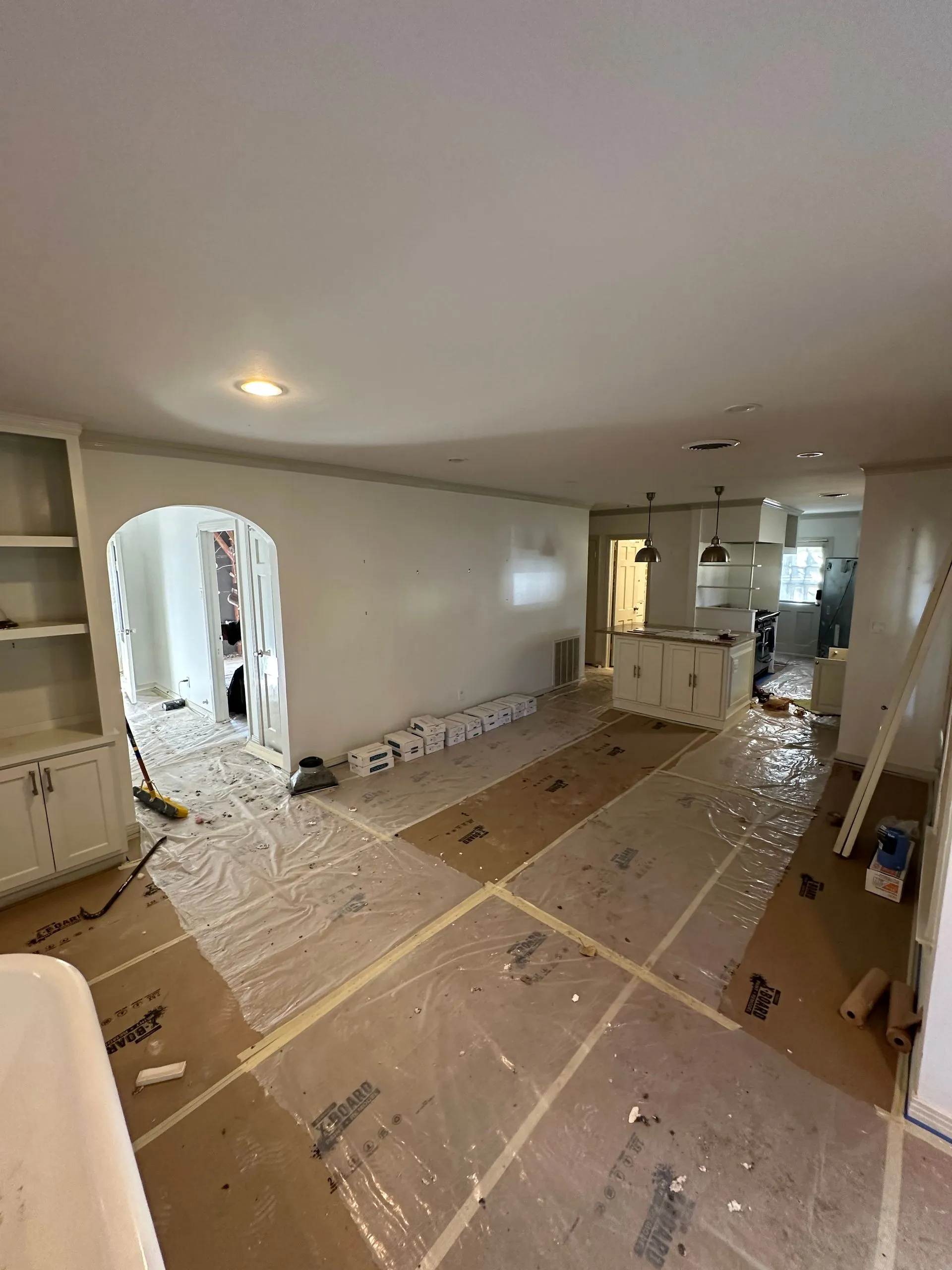 Residential interior prepared for remodeling with protective floor coverings, covered surfaces, orga 