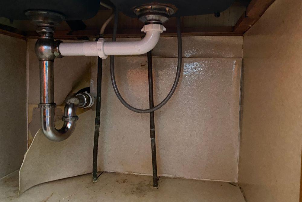 Minneapolis water damage restoration. Pictured here, the kitchen sink p-trap had a bad seal and dripped water over a long period of time.