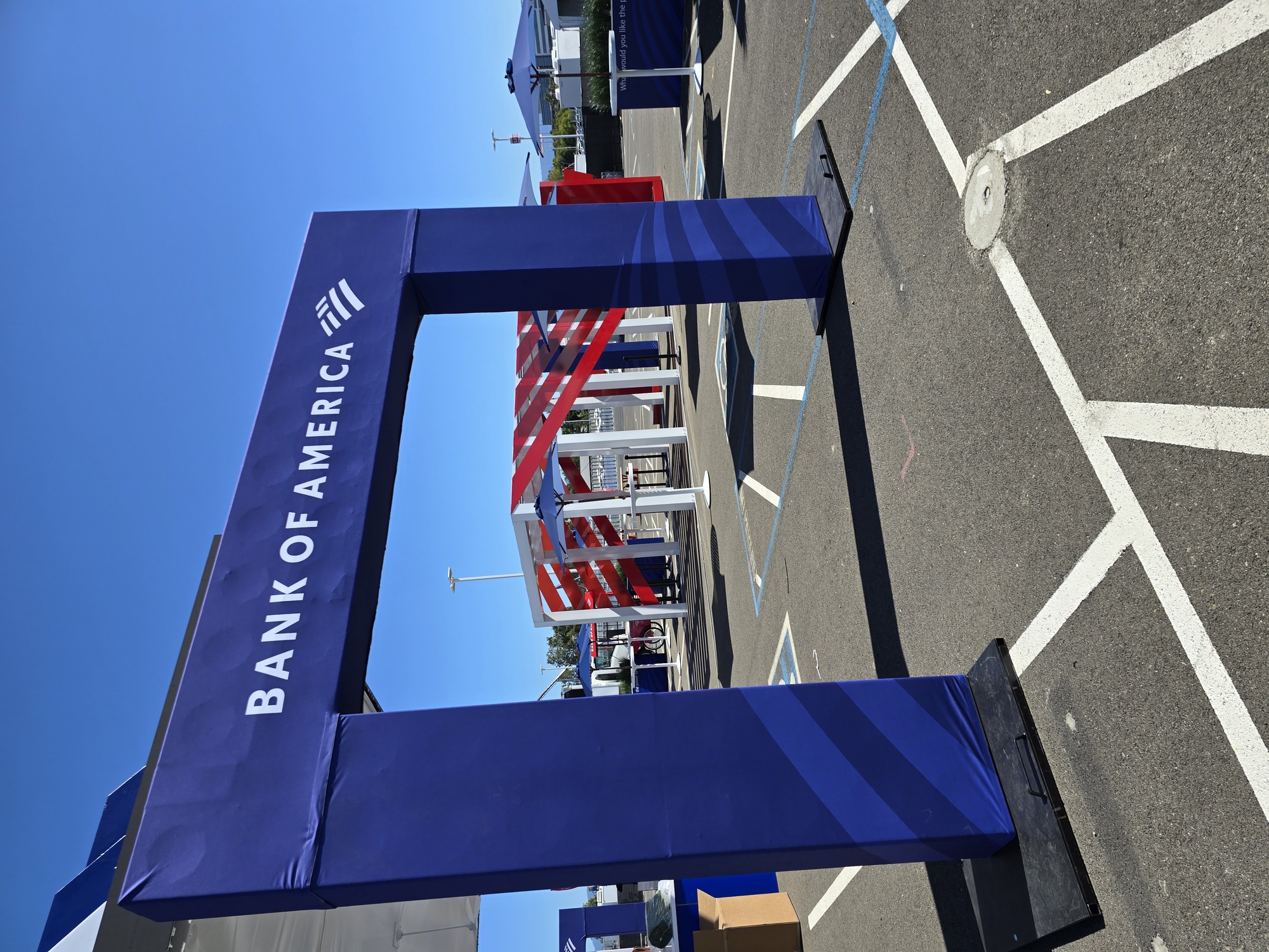 Bank of America branded entrance arch leading into a custom experiential marketing space with architectural displays, umbrellas, and event furnishings.