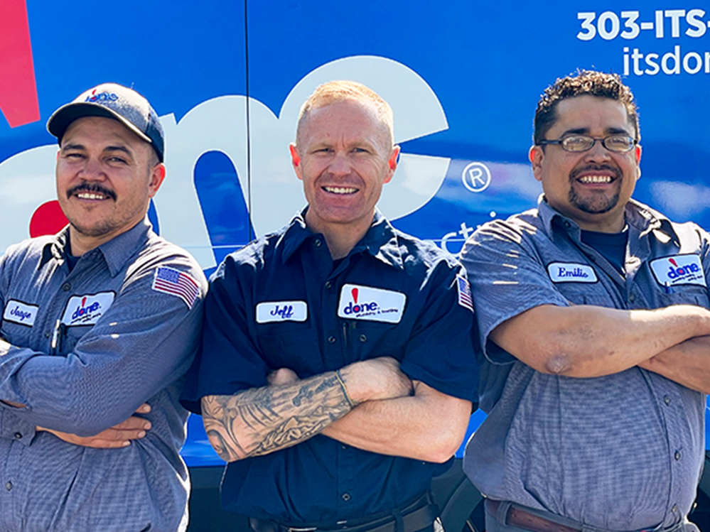 Done Plumbing, Heating, Cooling and Electric employees standing next to a truck