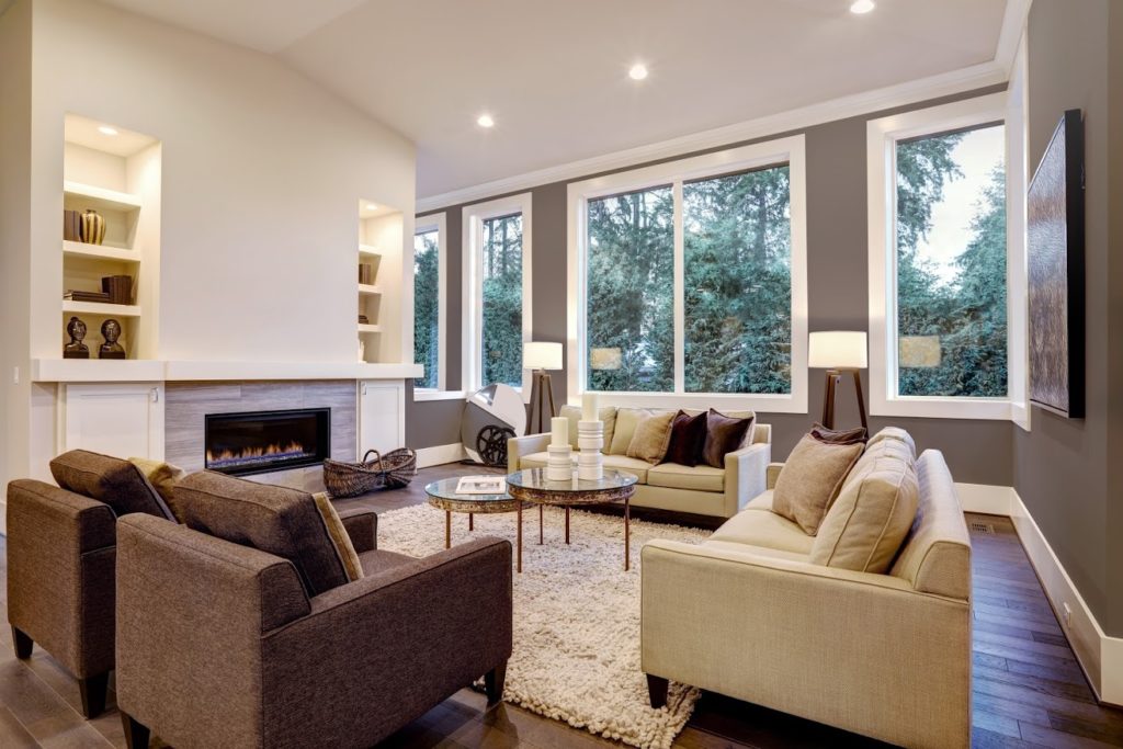The EcoTek 3200 Series Windows with MasterFit Trim adds a sleek, modern touch to this living room. Their large, unobstructed design fills the space with natural light, enhancing the contemporary decor and cozy ambiance while creating a seamless connection to the outdoors.