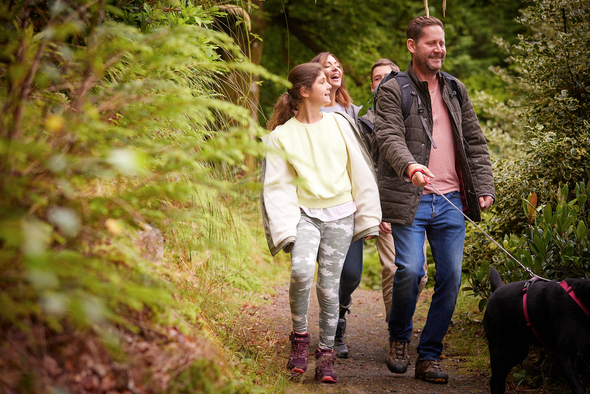 Family take a stroll with their dog through the grounds of Drimsynie Estate