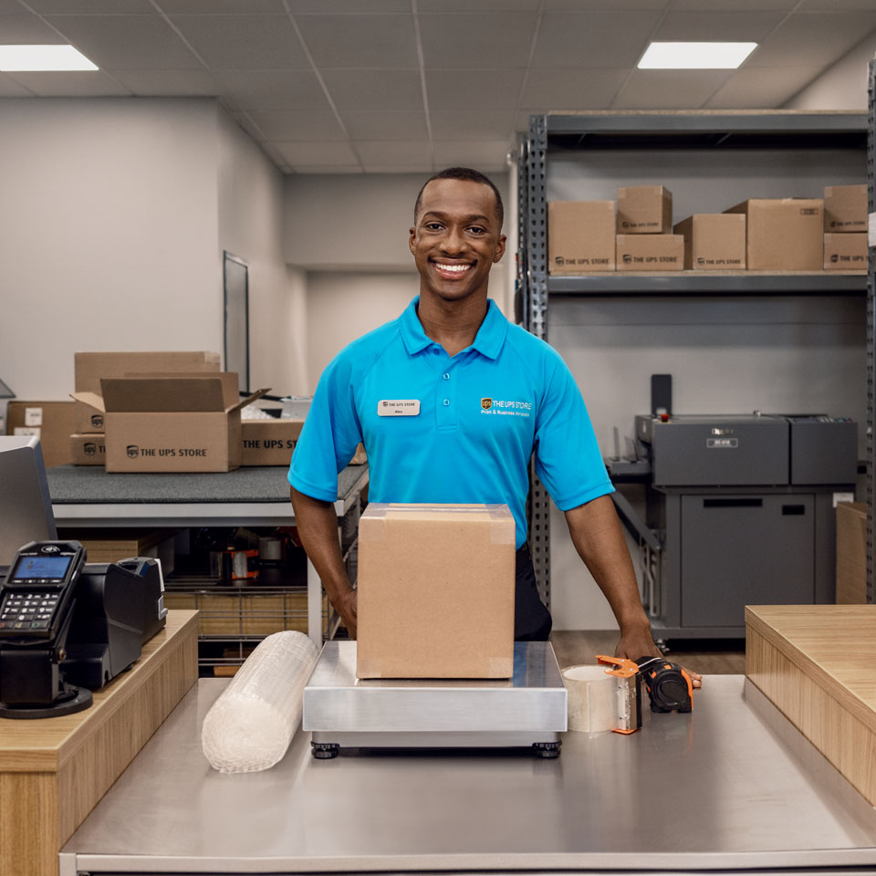 UPS Store associate packing a box