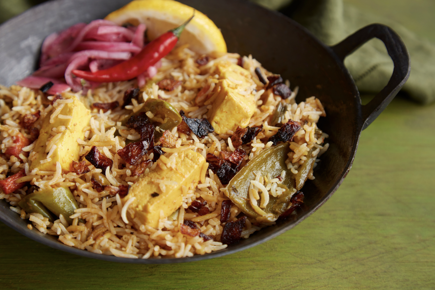 Paneer Biryani - - Cubes of Indian cottage cheese simmered in a mixture of spices, green bell peppers and aromatics until tender. Cooked with long grain basmati spiced rice. Garnished with fresh lemon, Thai chili pepper, fried and pickled onions.
- Vegetarian & Gluten Free