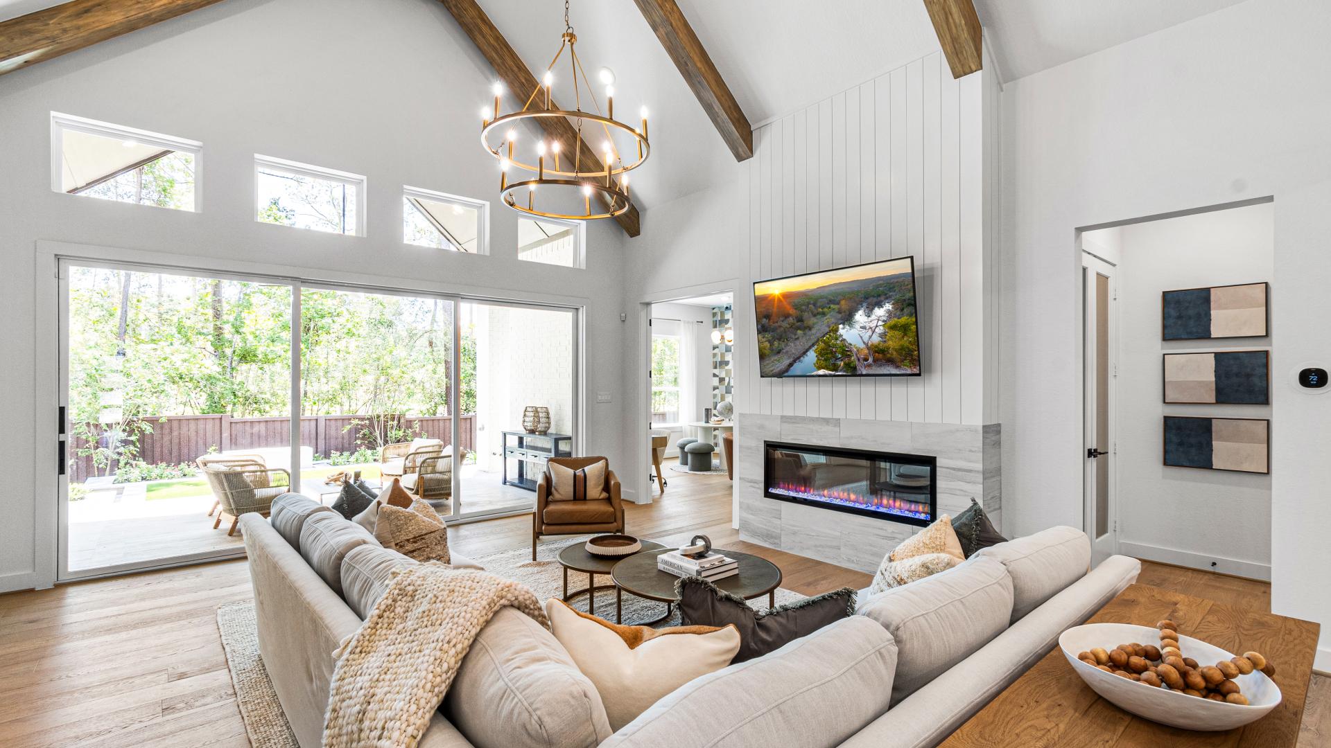 Great room with cozy electric fireplace, vaulted ceilings and wall of sliding doors that lead to covered patio