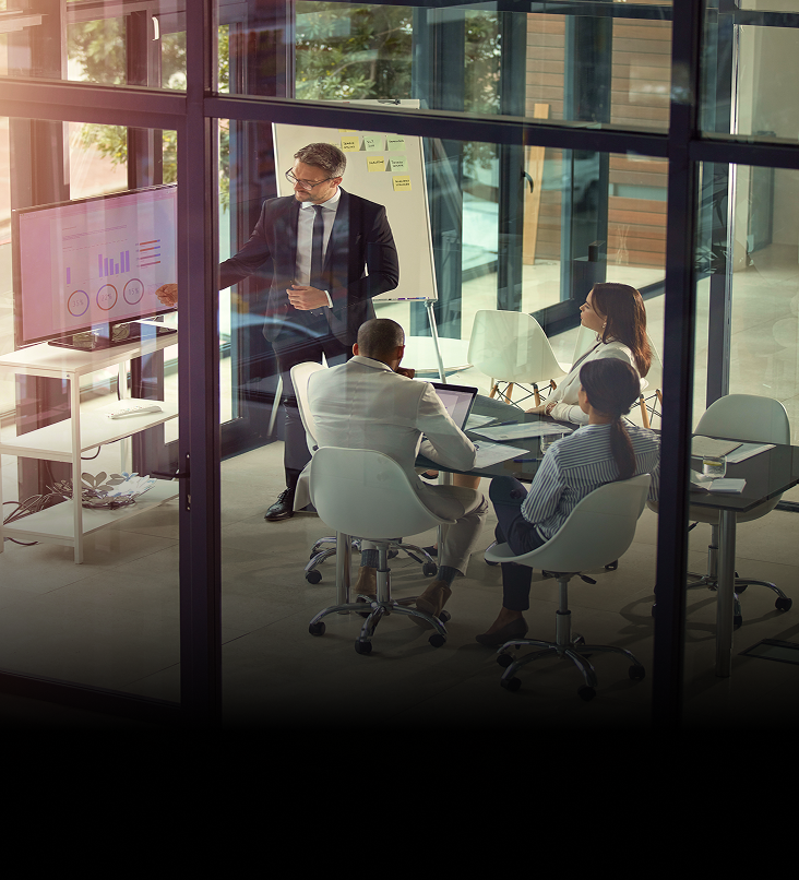 Wealth advisors meeting in a boardroom to go over projections and trends.