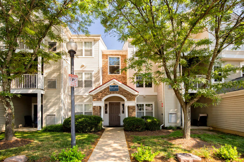 A small building with a brown roof is in front of a larger building.