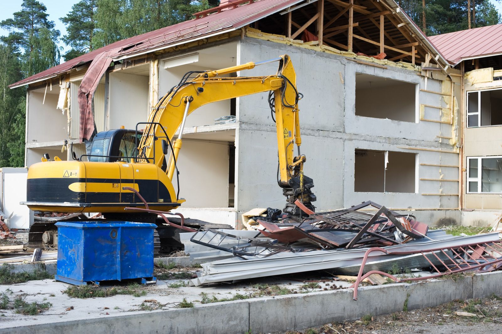 Excavator demolishing a residential structure, removing walls and debris, showcasing heavy equipment operation, site clearing, and professional demolition work for construction or renovation projects.