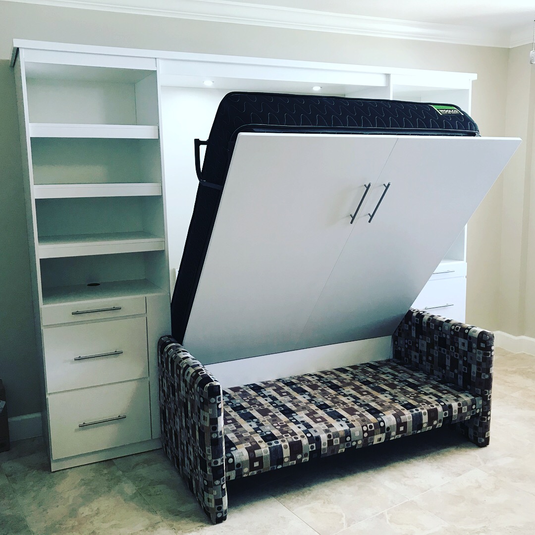 White Murphy bed with sofa opening in wall unit with shelving
