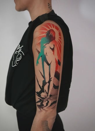 Eisenherz Tattoo und Piercing Magdeburg - Großflächiges Abstract Tattoo am Oberarm mit farbiger Silhouette, roter Sonne und grafischen Schwarzelementen. Ausdrucksstarkes Arm Tattoo im modernen Art Style für Keywords wie Abstract Tattoo, Color Tattoo...