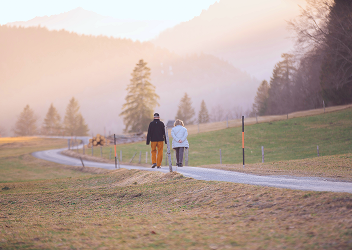 A couple walking along a path in a public park in the early morning.