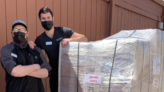 Associates at The UPS Store next to a freight shipment