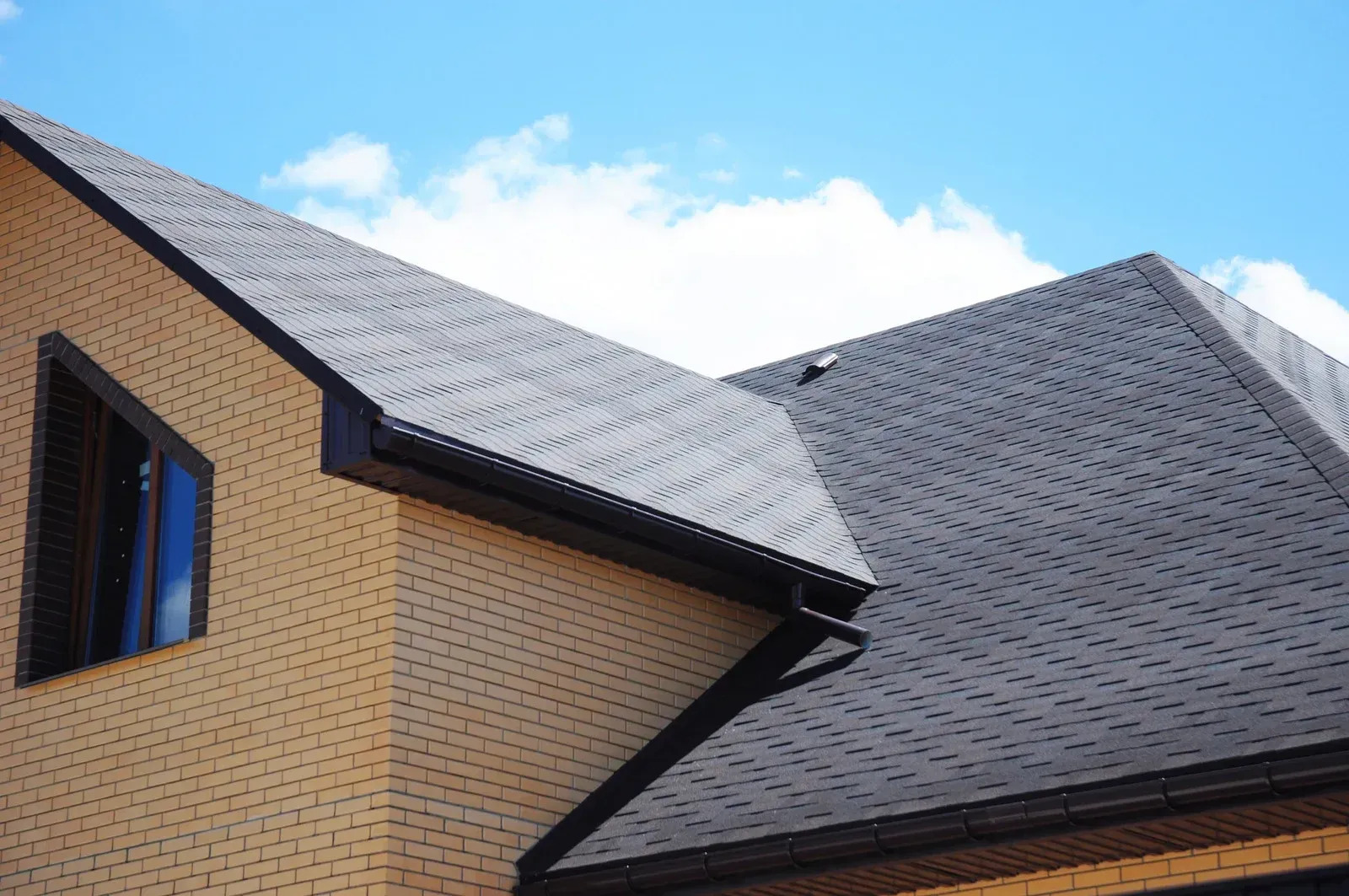 Modern brick home featuring a professionally installed asphalt shingle roof with clean lines, durable materials, and quality craftsmanship. The roof enhances curb appeal while providing long-lasting weather protection.