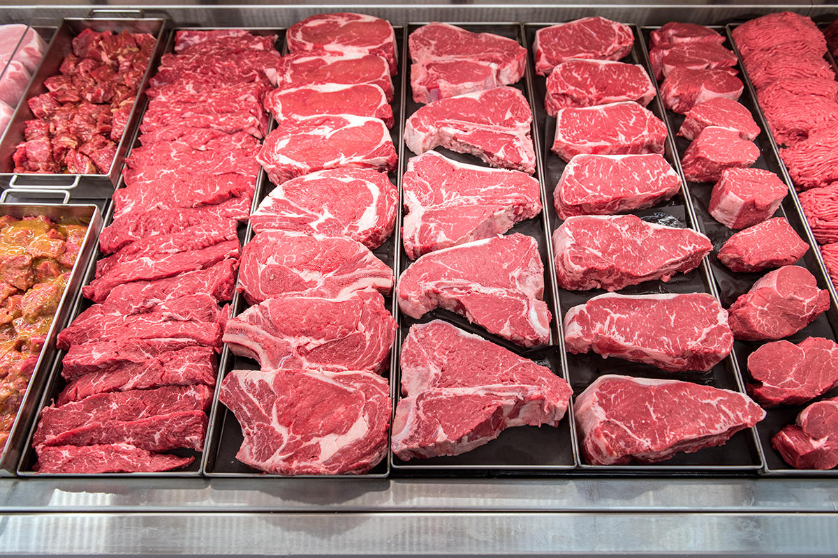 Tight shot of meat case displaying different cuts of beef and other meat