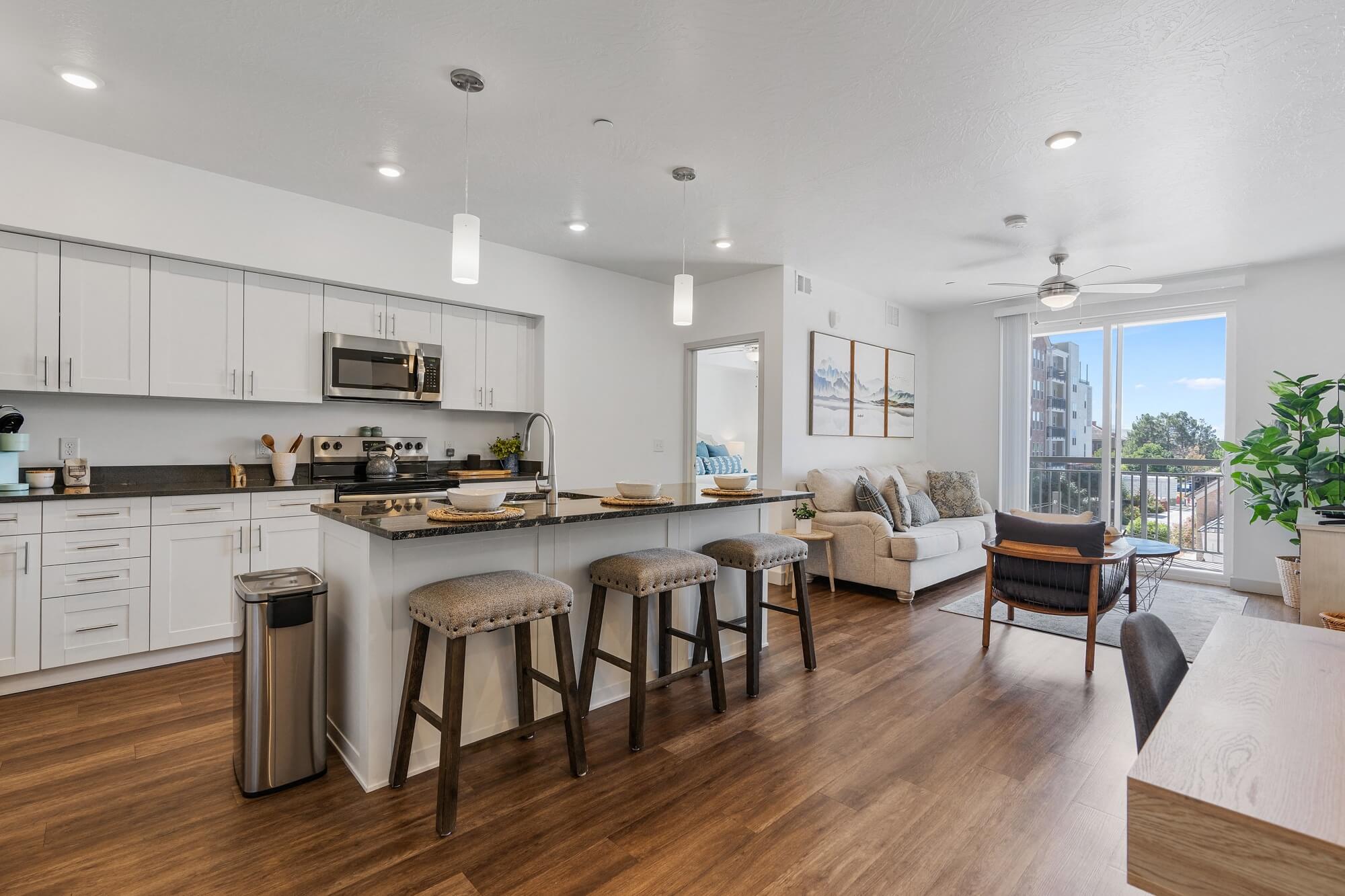 an open kitchen and living room with a large island and stools