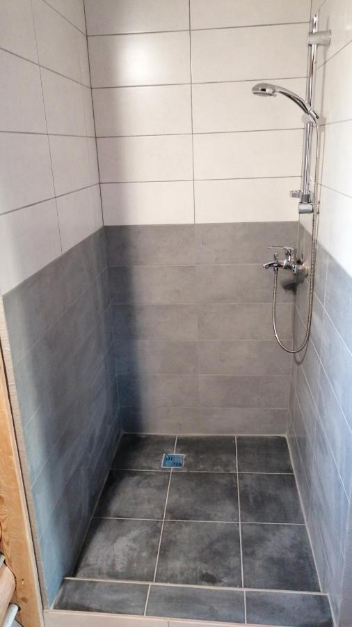 Gaiša un mājīga guļamistaba viesu namā 'Palmas' ar komfortablu gultu, koka detaļām un logu ar skatu uz dabu.