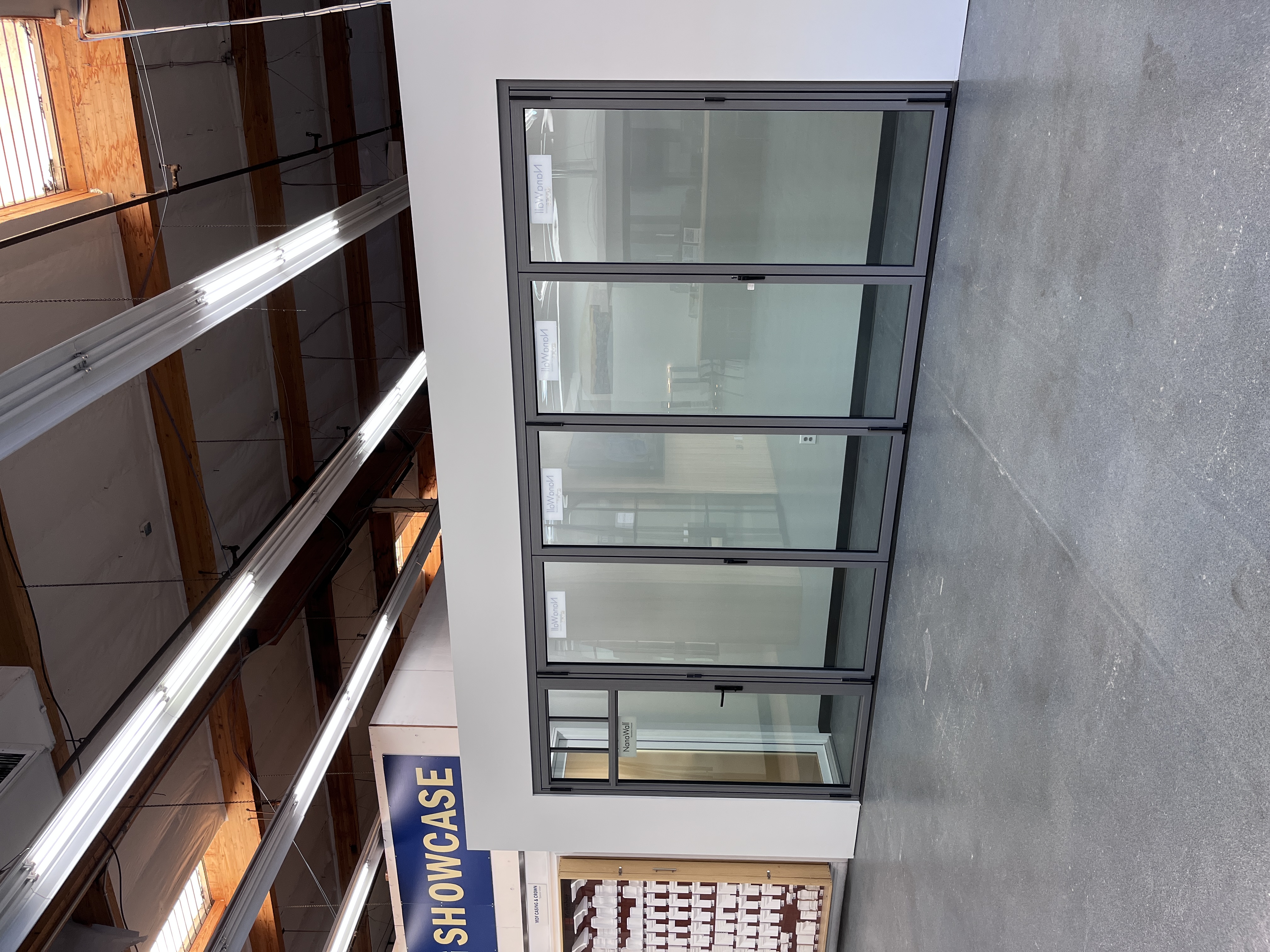 NanoWall folding glass door showroom display at Builders FirstSource Thousand Oaks, CA, shown fully assembled inside a mock room setting.