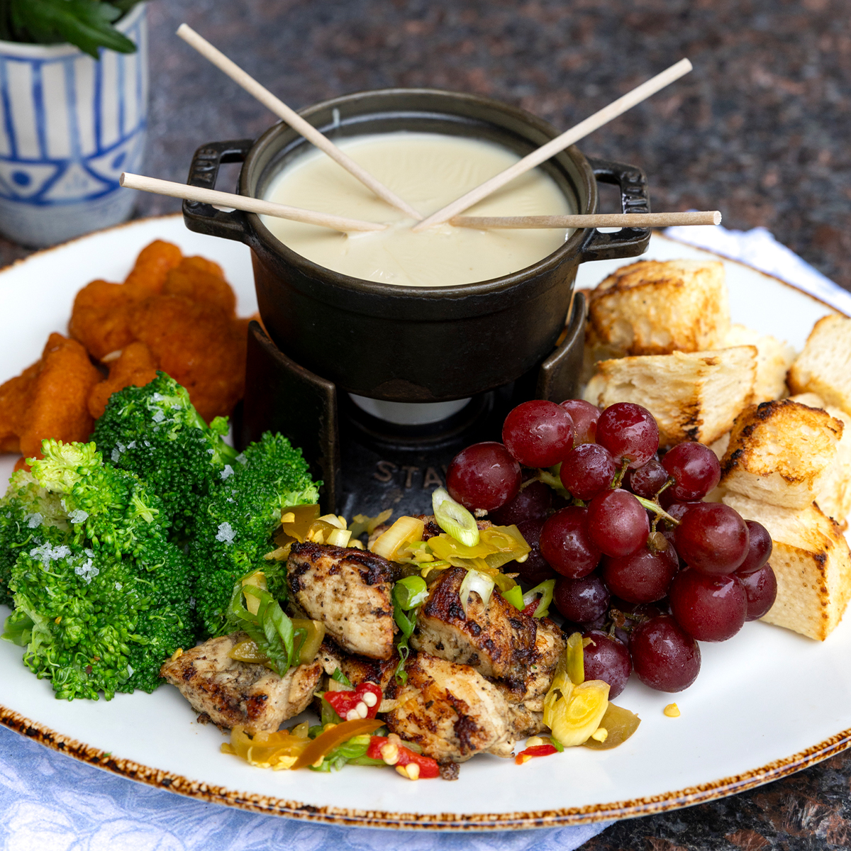 The Redstone Gouda Fondue | jerk chicken, sourdough croutons, fruit & veggies, crispy cauliflower