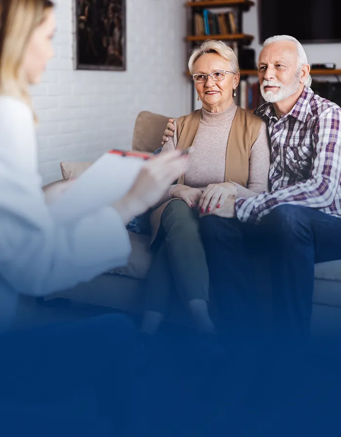 An elderly couple meeting with their wealth advisor.