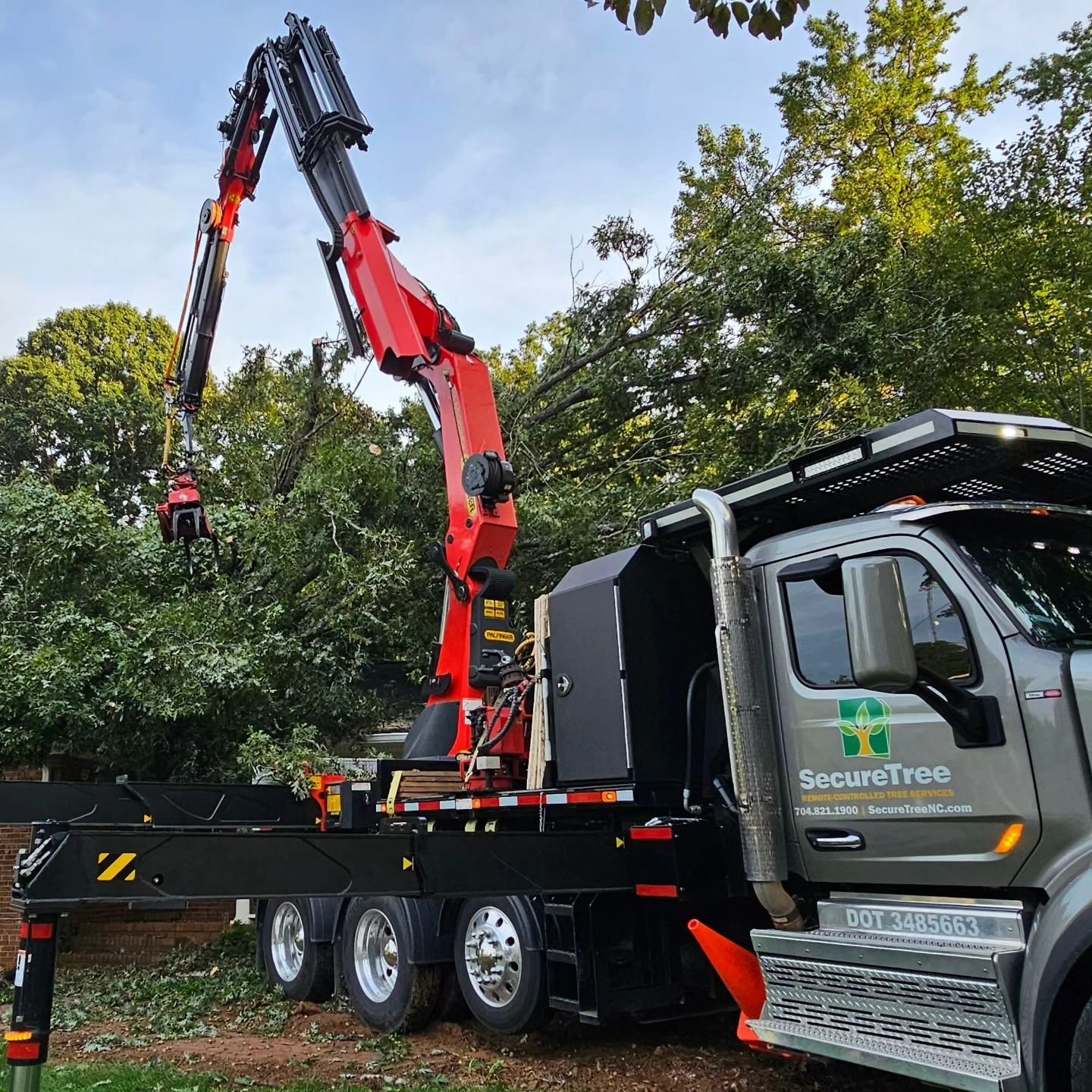 SecureTree Services remote-controlled grapple saw truck on a residential job