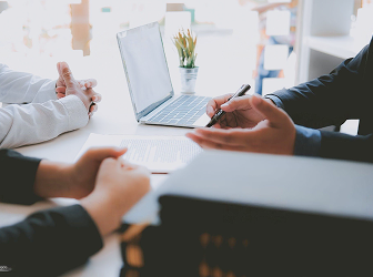 Close-up of an advisor discussing documents with a client couple.