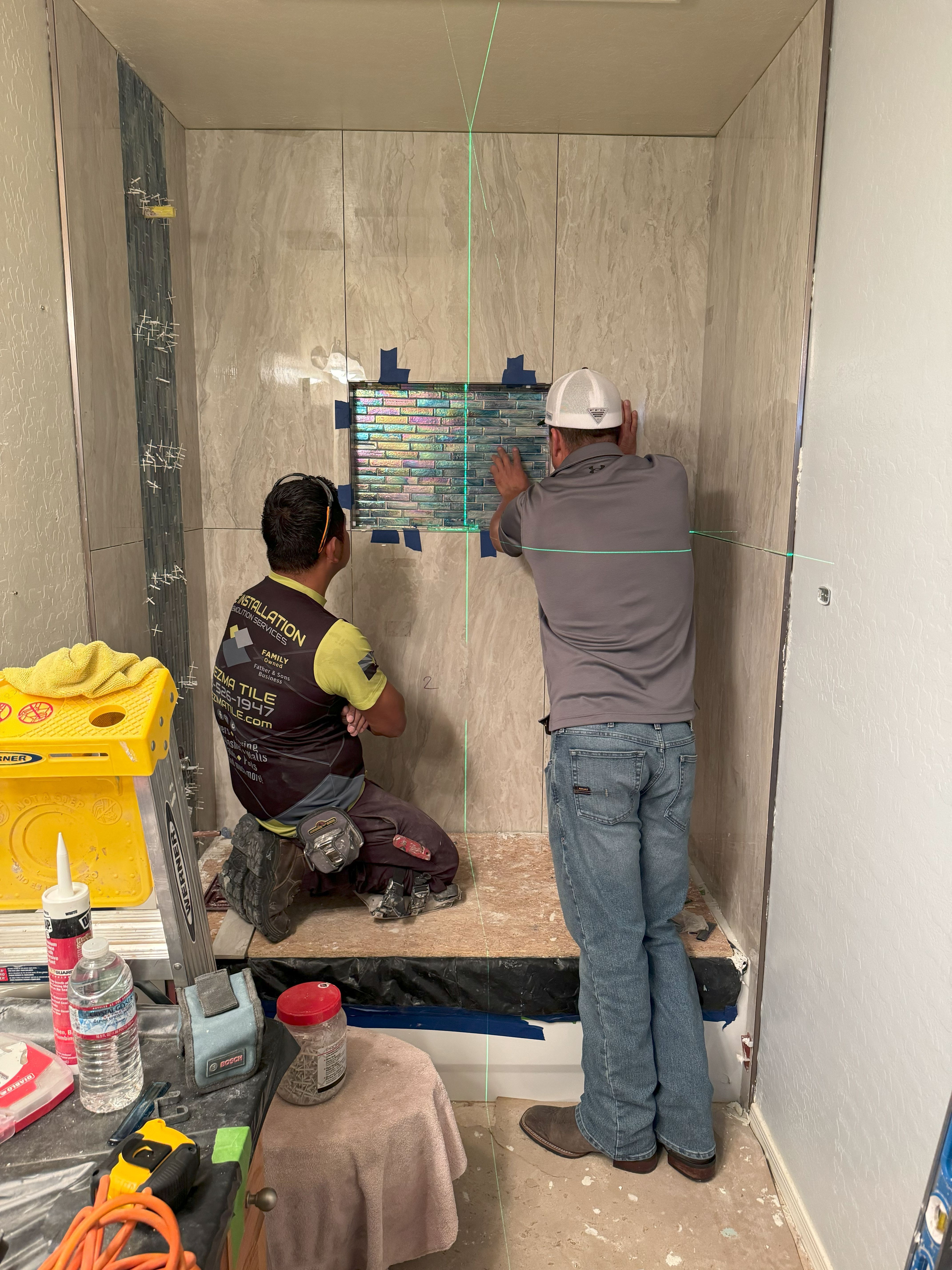 Our team at Ledezma Remodeling meticulously installs intricate tilework during a bathroom remodeling project. We take pride in delivering precision and craftsmanship to every renovation.