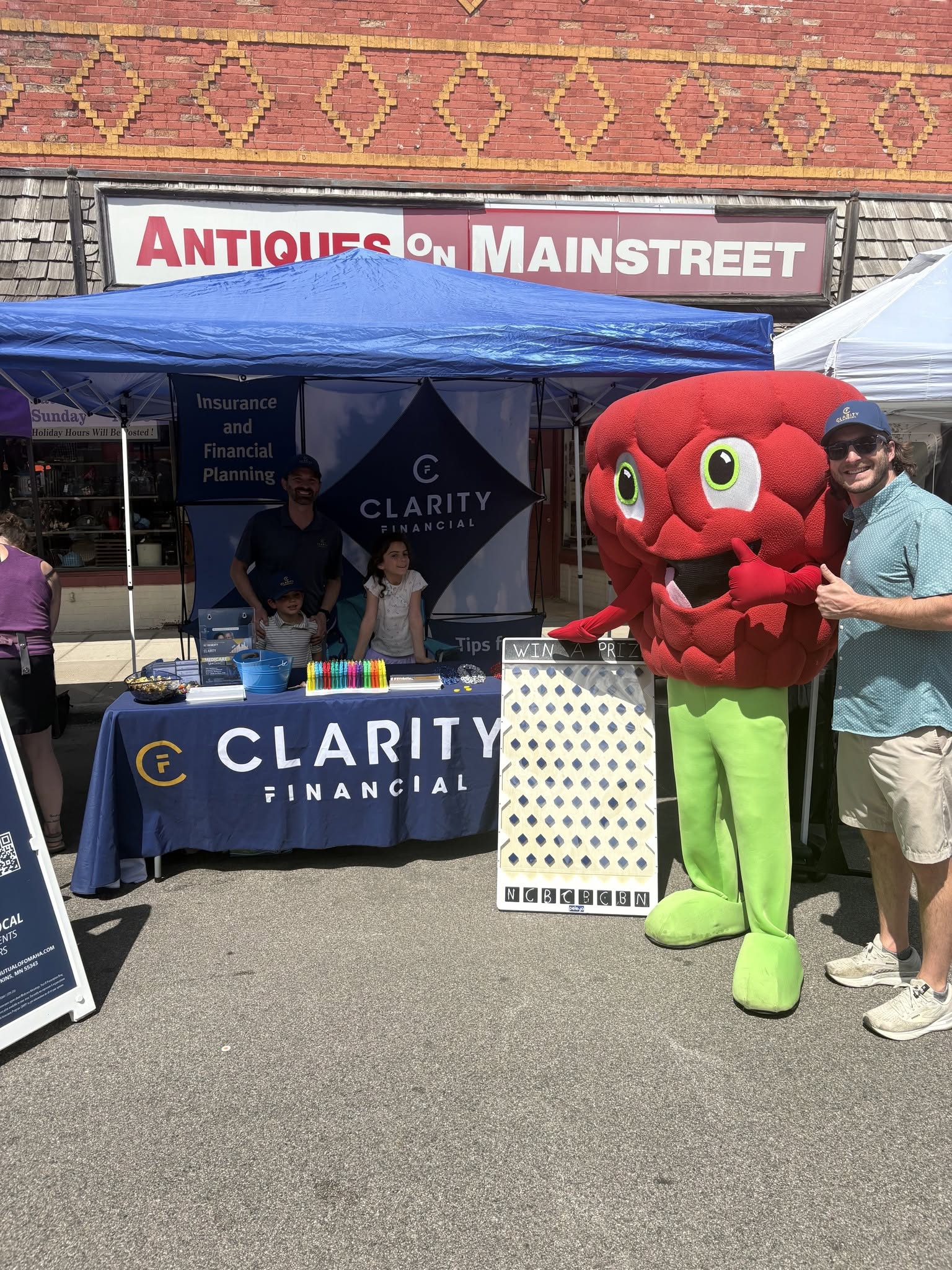Community involvement in action! The Clarity Financial team hosting a booth with interactive games, prizes, and financial planning information outside Antiques on Mainstreet during the annual Hopkins Raspberry Festival in Hopkins, Minnesota.
