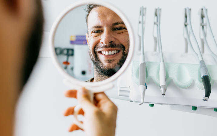 Man looking at his white teeth in a mirror