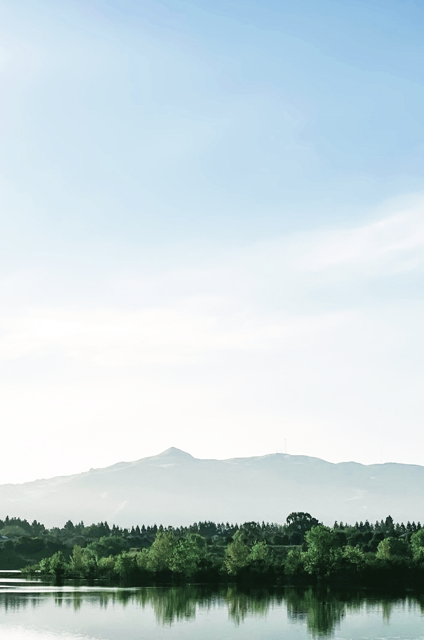 Beautiful landscape with calm water in the foreground and mountains in the background.